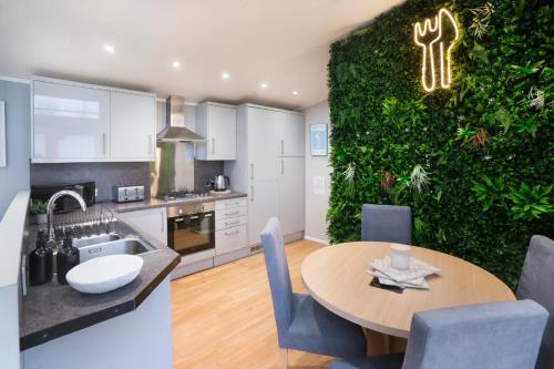 a kitchen with a table and a green wall at Silverdale Lodge, HotTub, Wi-FI, Quiet & Sleeps 4 in Warton