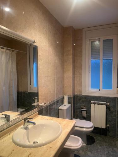 a bathroom with two toilets and a sink at Hotel Berna - Valdeorras - Camino de Invierno in La Rúa