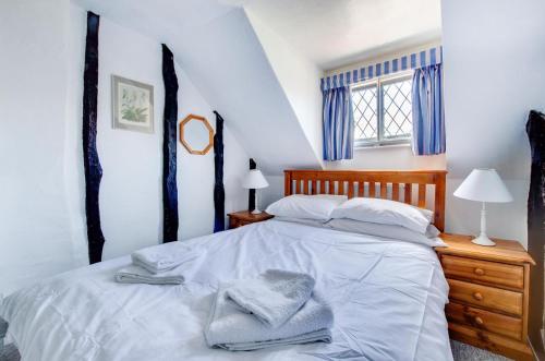 a bedroom with a white bed with blue curtains at 2 Bed in Southwold oc-hdanby in Southwold