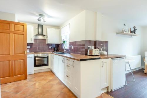 a kitchen with white cabinets and a counter top at 3 Bed in Little Walsingham oc-1229 in Little Walsingham