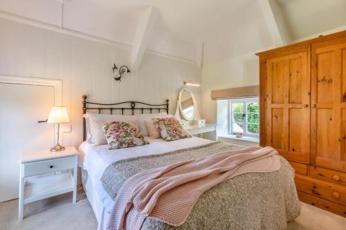 a bedroom with a bed with a dresser and a mirror at 3 Bed in Berrynarbor oc-courtc in Berrynarbor