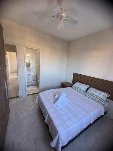 a bedroom with a large bed with a ceiling fan at Apê 250m da Orla de Piúma in Piúma