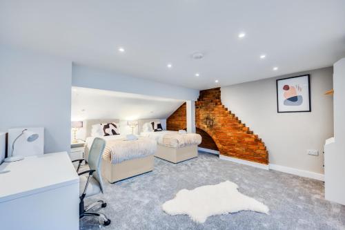 a bedroom with two beds and a brick wall at 4 Bedroom 4 Bathroom House - Sleeps 7 - Prime Location, Free Parking, Self-Check-In, Workspace, Fast Wifi and Smart TV with Virgin TV and Netflix by Yoko Property in Northampton