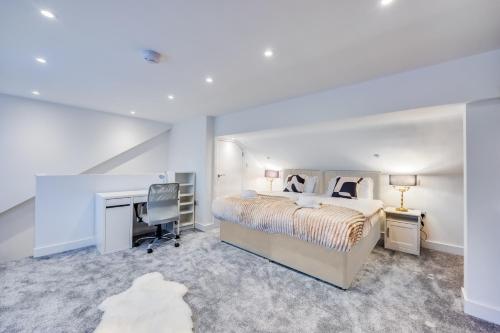 a bedroom with a bed and a desk and a computer at 4 Bedroom 4 Bathroom House - Sleeps 7 - Prime Location, Free Parking, Self-Check-In, Workspace, Fast Wifi and Smart TV with Virgin TV and Netflix by Yoko Property in Northampton
