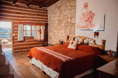 a bedroom with a bed and a stone wall at Hotel Divisadero Barrancas in El Divisadero