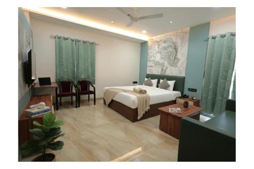 a bedroom with a bed and a desk and a television at Hotel Anmol One in Indore