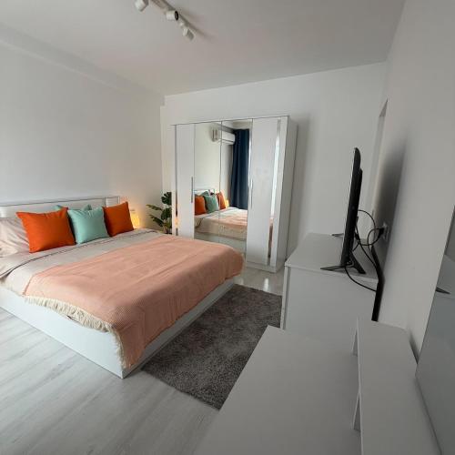a white bedroom with a bed and a mirror at Otopeni Studio C2 3 Airport Therme in Otopeni