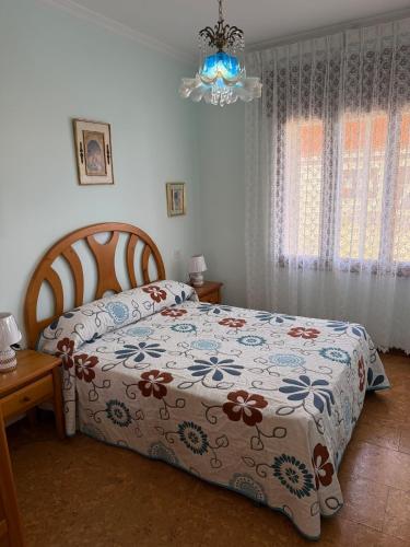 a bedroom with a bed and a chandelier at Villa Laxes in Burela de Cabo
