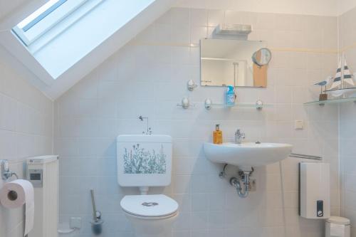 a white bathroom with a toilet and a sink at Frankenblick in Frankenau