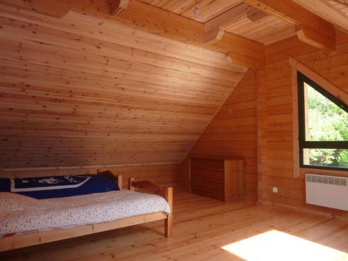 a bedroom with a bed in a log cabin at Le Chalet de Seb in Ingouville