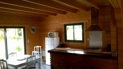 a kitchen in a wooden cabin with a refrigerator at Le Chalet de Seb in Ingouville