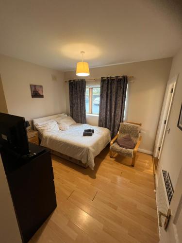 a bedroom with a bed and a chair and a television at Kildare cozy home in Kildare