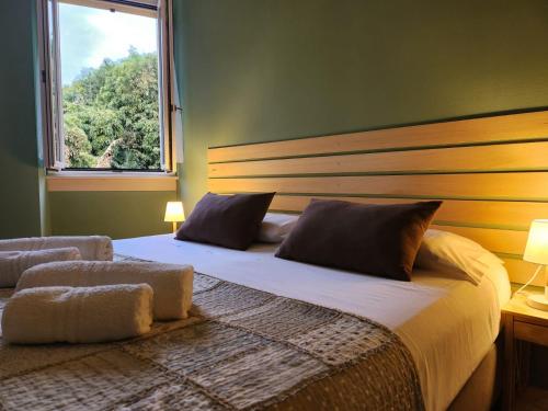 a bedroom with a large bed with a large window at Bellagio Love apartment Pool Near lake Free parking in Bellagio