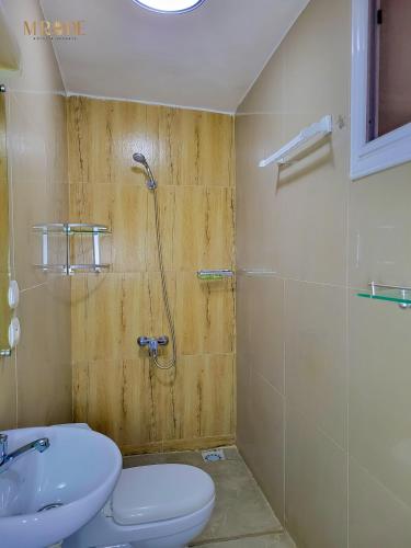 a bathroom with a shower and a toilet and a sink at Appart M'Rode Baguida in Lomé