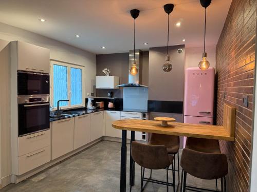 una cucina con un tavolo di legno e un frigorifero rosa di Maison de rêve 