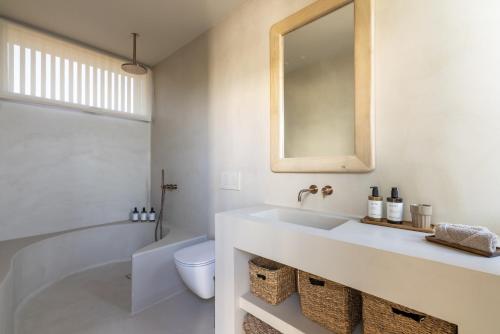 a bathroom with a sink and a toilet and a mirror at Gara Suite Boutique Design Villa Private Pool in Lajares