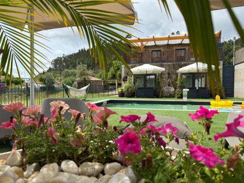 a table with flowers and chairs next to a pool at Villa Stay Luxury Property Ponte De Lima in Ponte de Lima