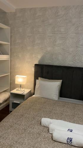 a bedroom with a bed with a black headboard and a lamp at Odivelas Place 1 in Odivelas