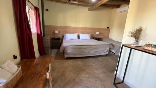 a bedroom with a bed and a couch in a room at Posada Solar de las Piedras in Fiambalá