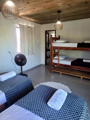 two beds in a room with two bunk beds at Vila Mukaú in Porto Seguro
