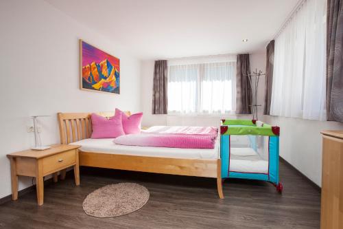 a bedroom with a bed with pink and pink pillows at Art-Apartments Kartnaller superior in Neustift im Stubaital