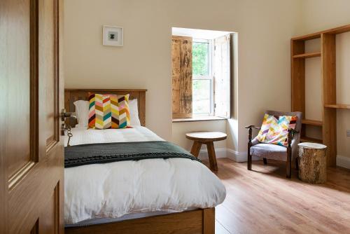 a bedroom with a bed and a chair and a window at Kylemore house boutique apartments - Diamond Lounge in Kylemore