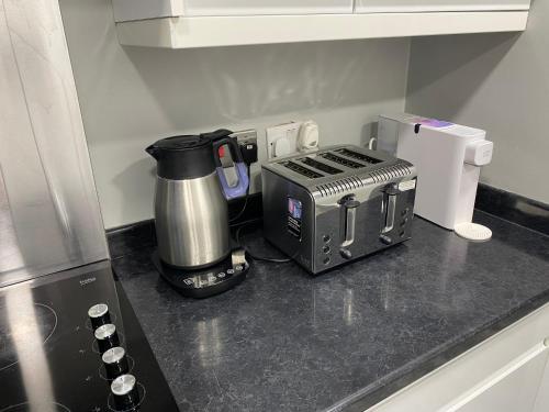 a kitchen counter with a coffee maker and a toaster at Marvel in Abbey Wood