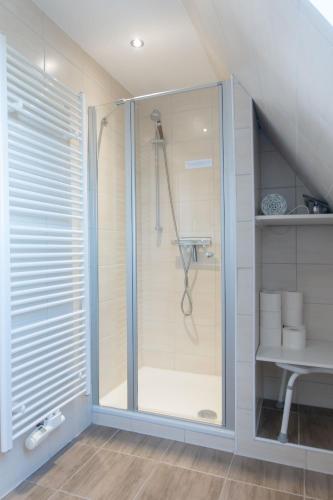 a shower with a glass door in a bathroom at Ferienhaus Nordsee2 in Dornum