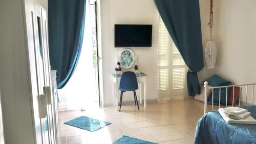 a bedroom with a desk and a blue chair in a room at ENGI CASA VACANZE in Naples