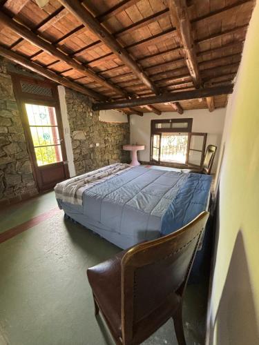 a large bed in a room with a chair at Villa Pellegrini in Trapiche