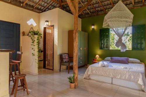 a bedroom with a bed with a net hanging from the ceiling at Casa Aroeira Massarandupió in Entre Rios