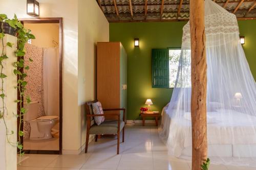 a bedroom with a bed and a toilet in a room at Casa Aroeira Massarandupió in Entre Rios