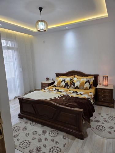 a bedroom with a large wooden bed in a room at Appartement indépendant de villa in Tipaza