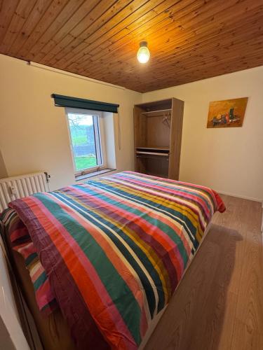 a bed in a room with a colorful blanket on it at Appartement 2 chambres in Messancy