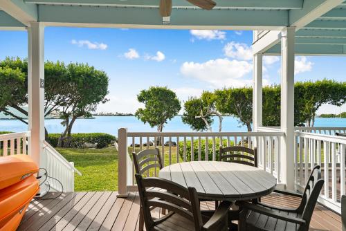 a table and chairs on a deck with a view of the water at 5035 "Villa del Sol"- Amazing Sunset Views! 2bed 3bath in Duck Key