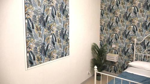 a bedroom with a blue and gold wallpaper on the wall at ENGI CASA VACANZE in Naples