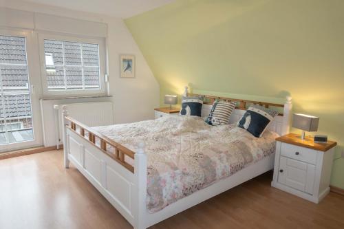 a bedroom with a white bed and a window at Ferienhaus Nordsee2 in Dornum