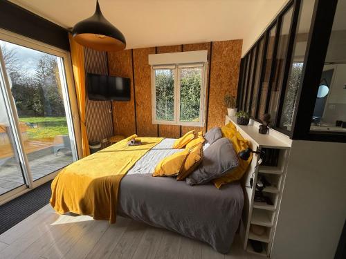 a bedroom with a bed with a yellow comforter at Alice's Studio and Oasis in Poitiers