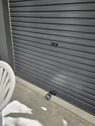 a garage door with a cell phone in front of it at Little Hill on Sycamore in New Plymouth