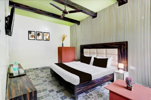 a bedroom with a large bed and a red table at Hotel O Tehsil Chowk Doon Hospital Formerly Hotel Comfort in Dehradun