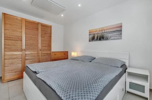 a bedroom with a bed and a wooden closet at Apartment MINT in Senec