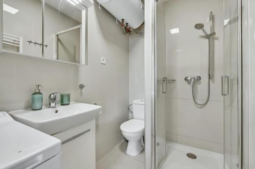 a white bathroom with a toilet and a shower at Apartment MINT in Senec