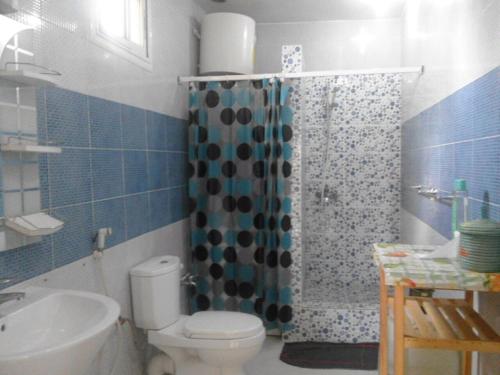 uma casa de banho com um WC, um chuveiro e um lavatório. em Residence Les Calanques em Dakar