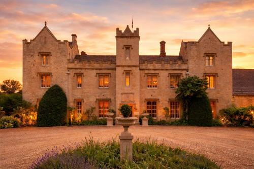 an old castle with a sunset in the background at Weston Manor Hotel in Bicester