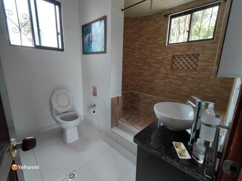 a bathroom with a toilet and a sink and windows at CAMPESTRE VILLA LUNA Quinbaya in El Tigre