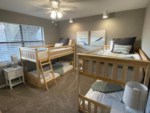 a room with two bunk beds and a ceiling fan at Hadley's Place at Pointe Royale, Pristine 2 Bed 2 Bath Condo in Branson