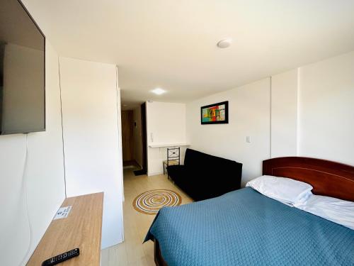 a bedroom with a bed and a chair in it at Apartamento mar in Tunja