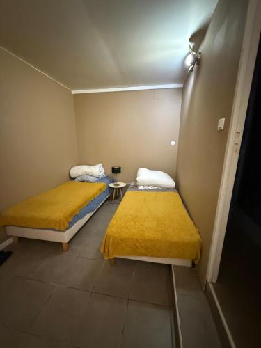 two beds in a small room with yellow sheets at u limone in Porticcio