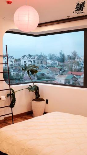 a bedroom with a window with a view of a city at CozyhomeDaLat in Khu Chi Lăng