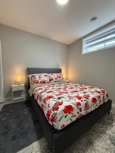 a bedroom with a bed with a red and white comforter at Slice Of Paradise in Calgary